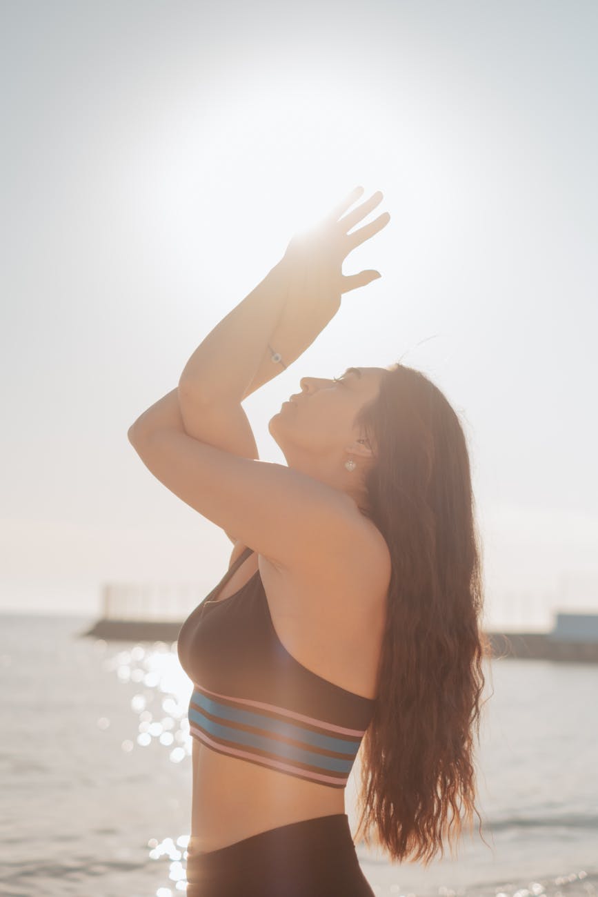 Silhouette of a person in a powerful yoga pose against a sunrise.