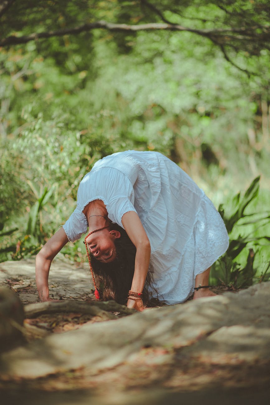 Woman in a calm yoga pose in a dark, serene environment.